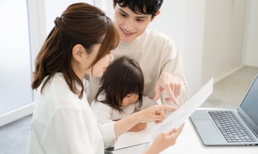 子どもと書類を見る家族